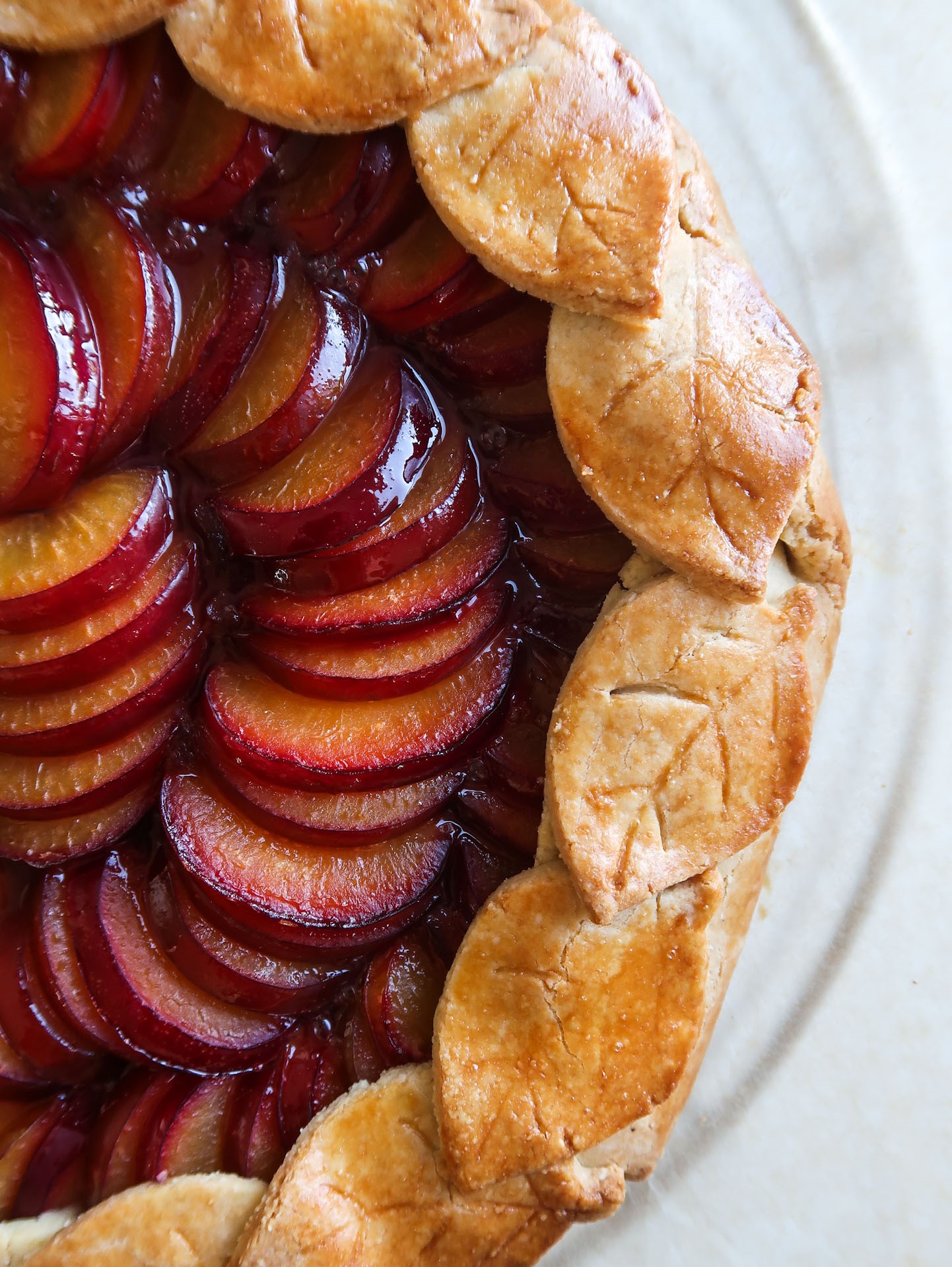 tart with decorated crust and slices of plum
